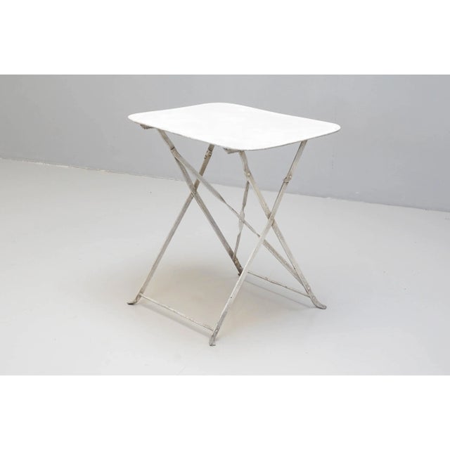 Early 20th century white painted steel rectangular garden table on folding base.