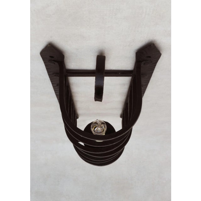 Unusual wrought iron wall light sconce from early 20th century france. Artisan-made caged ‘candle light’ in heavy hand-...