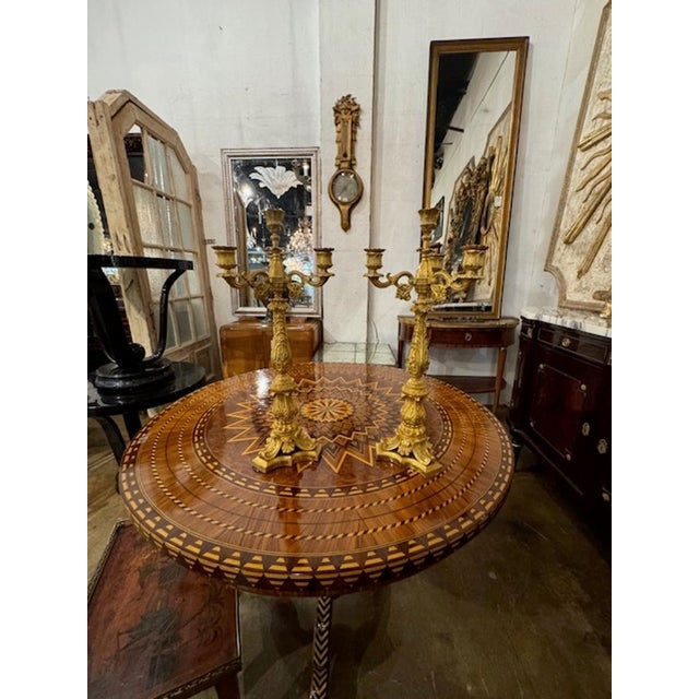 This product is a pair of 19th-century French Louis XVI gilt bronze candelabras. These feature high quality craftsman ship...