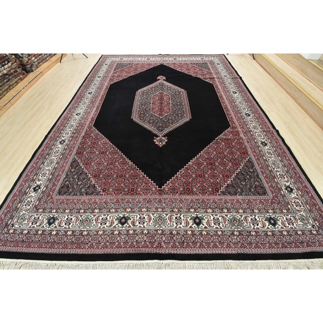 A vintage traditional Bidjar rug hand-knotted with an all-wool pile on a cotton foundation. This oriental rug features a...