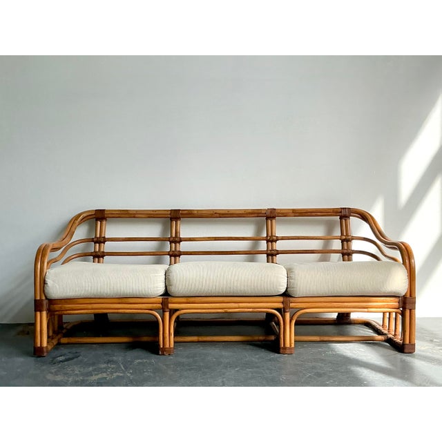 Evoke the breezy elegance of a Palm Beach lanai with this stunning vintage bent rattan sofa, attributed to the renowned...