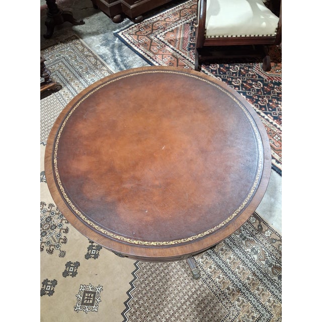 Elegant Regency-style drum table inspired by English design, featuring a circular profile and a leather inset top accented...