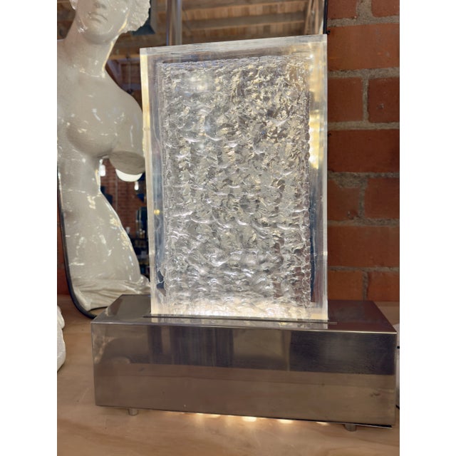 This methacrylate table lamp features a textured, crystalline appearance that is both modern and striking. The lamp's...