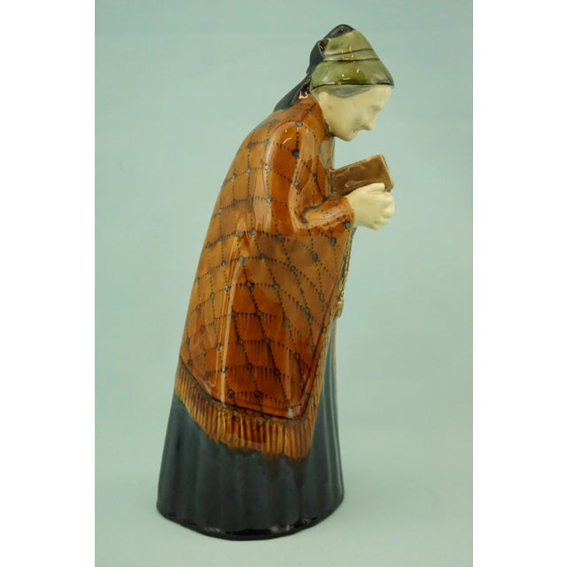 Item description: delightful cast ceramic sculpture, glazed and richly vitrified, depicting an elderly religious woman...