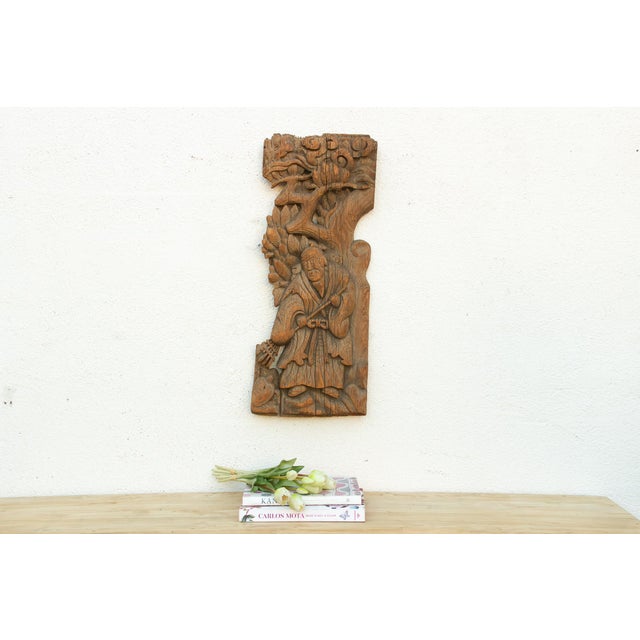 This piece shares real kinship with the sage-and-turtle panel just before it, same rustic, hand-worked carving style, same...