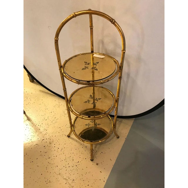 Faux bamboo églomisé three-tier ètagerè Stand. Nice and finely decorative three-tier Stand of gilt metal design having...