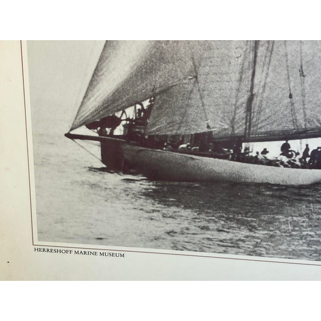 This striking black-and-white vintage poster features three legendary America’s Cup racing yachts: Columbia, Reliance, and...