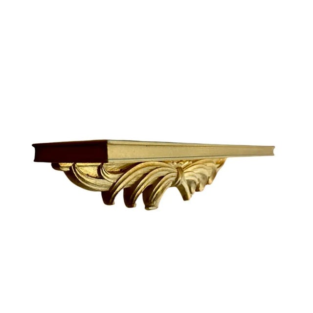 A lovely, vintage gilt wall shelf by Syroco. Features a rectangular wall shelf adorned with a Florentine style bow detail...