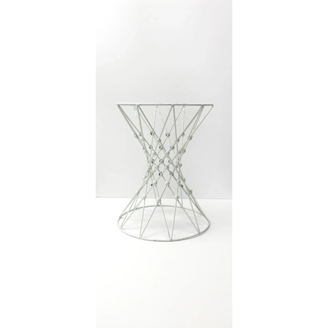 A white enamel and metal side table with a crisscross design and hourglass shape. A versatile side, accent, or drinks...