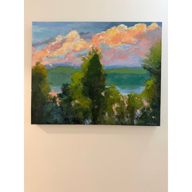Sunset featuring beautiful colors in the clouds as seen through the forest above the mountain lake. One-of-a-kind original...