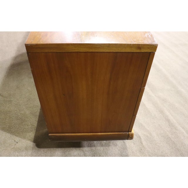 Low mid-century modern dresser with six drawers and sculpted ribbon base.