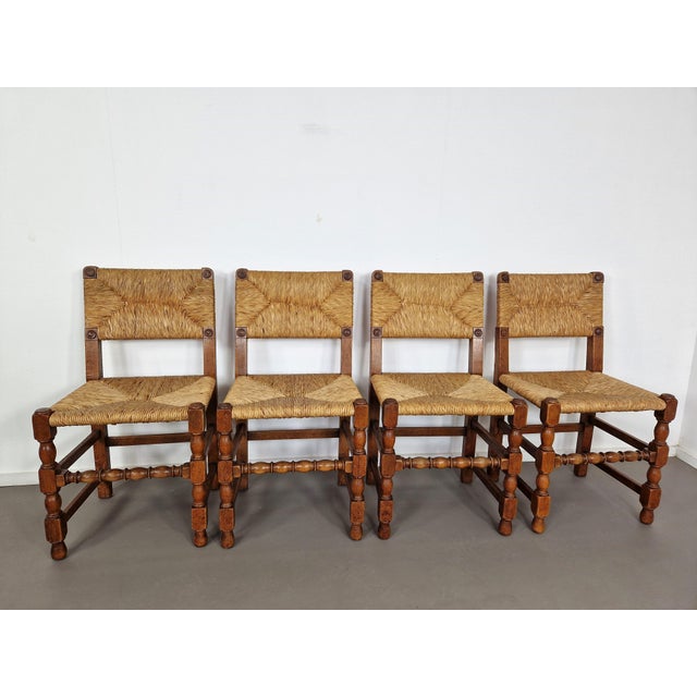 Set of four 1930s chairs in oak with carvings, rush seat and backrest and that typical French rustic vibe. We also have...