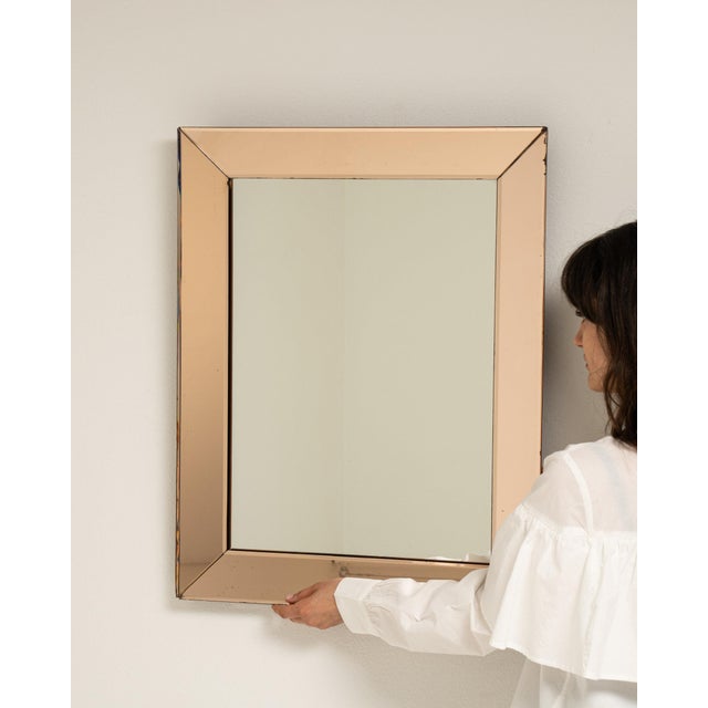 This mirror makes its impression through rose gold/champagne frame, rectangular. It was made in France during 1940s, a...