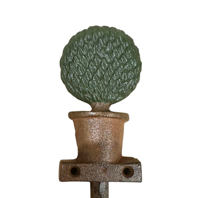 A charming, set of vintage hooks. Each features a cast iron, potted boxwood topiary with a cast hook to the bottom. Two...