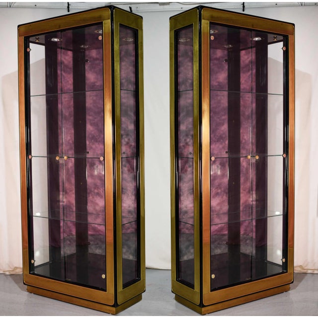 A pair of outstanding modern Mastercraft black lacquered brass and glass display cabinets or vitrines. These beautiful...