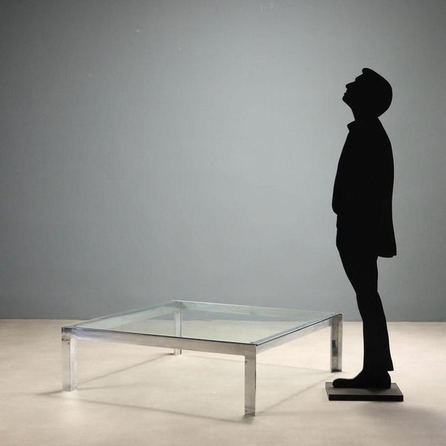 Center coffee table from the 1970s, featuring a minimalist design typical of the era. The structure is made of metal while...