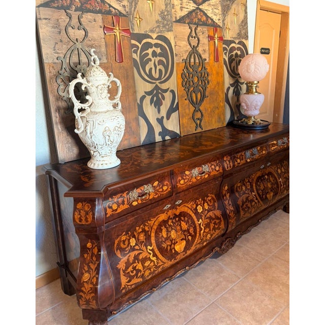 This stunning bombe-shaped credenza exudes old-world craftsmanship. Featuring intricate floral marquetry inlays across its...