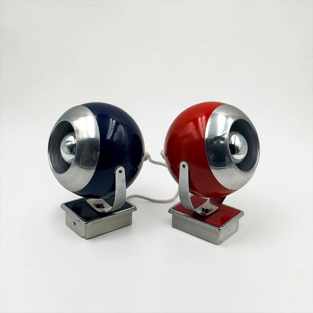A matching pair of vintage space age eyeball wall lamps from the 1970s, distinguished by their contrasting red and dark...