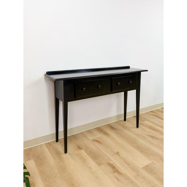 This clean and well-made Nichols and Stone solid black wood console is a sleek and versatile modern transitional entryway...