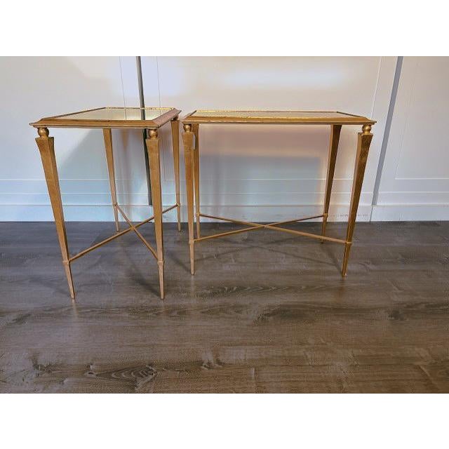 This stunning side table feature a gilded finish with a mirrored table top. The juxtaposition of the antique shape and leg...