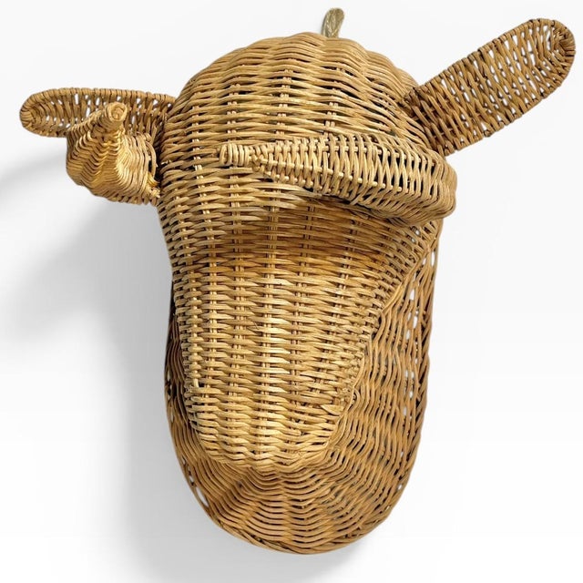 A striking and iconic vintage wall sculpture featuring a bull's head, hand-woven from natural wicker or rattan. This piece...