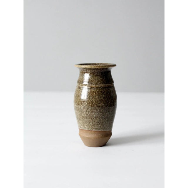 A studio pottery vase dated 2017, hand-crafted with a slender, elegant silhouette. The surface features a striking green...
