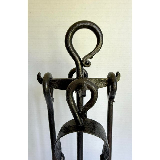This vintage wrought iron fireplace set features a beautifully sculptural design with hammered textures, oversized loop...