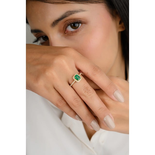 This modern mini ring features a striking 0.75-carat octagon-cut emerald, set in a delicate halo of sparkling white...
