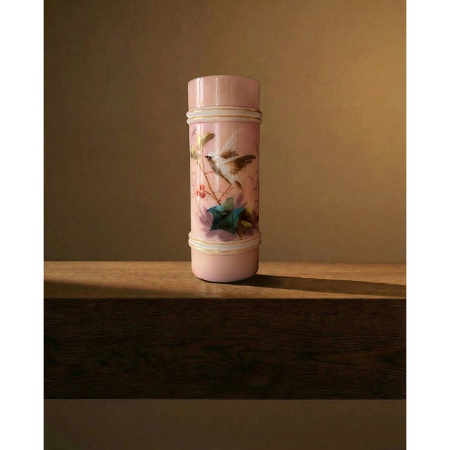 A charming example of Victorian decorative glasswork, this petite cylindrical vase is rendered in soft blush-pink opaline...