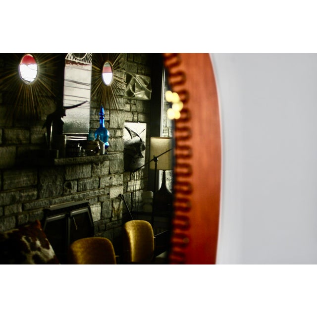 Large wall mirror designed by the Austrian Josef Frank and made in Sweden, mounted on a spiral teak steel plate secured by...