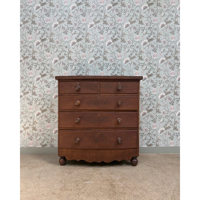 Elegant and timeless, this large antique english chest of drawers captivates with its generous proportions and the warmth...