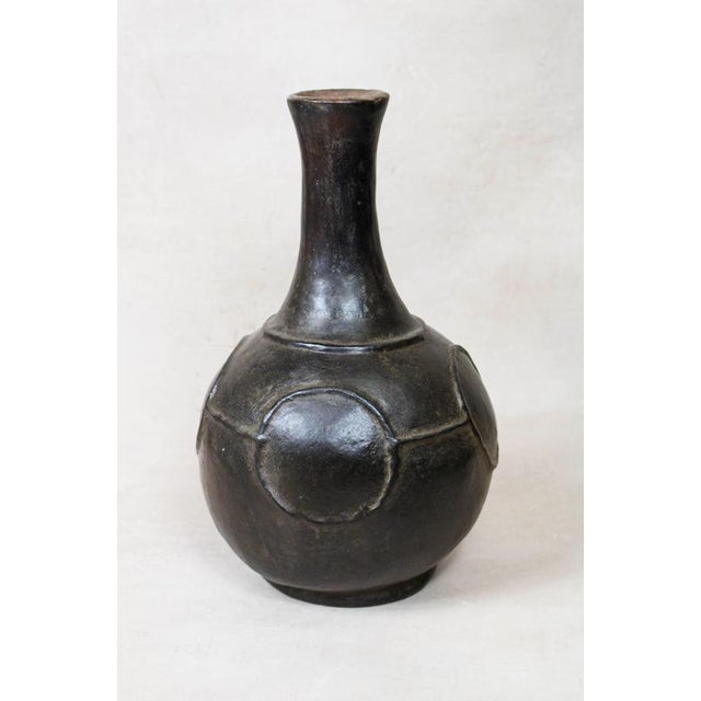 This Mangbetu Vase is a masterful blend of functional pottery and soulful sculpture, hand-crafted by the Mangbetu people...