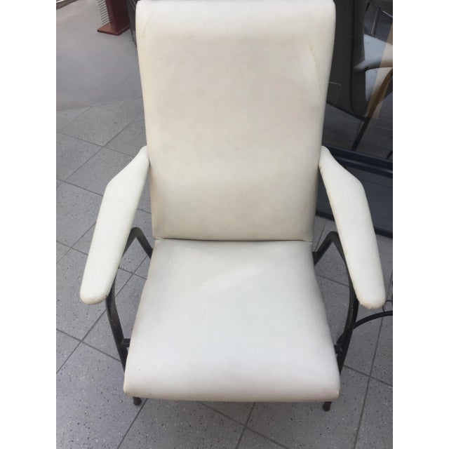 White skai armchair in the style of Pierre Guariche 1960 design. Seat in good condition. Wrought iron and brass base....