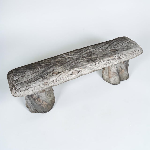 Vintage faux bois concrete garden bench featuring a thick plank seat supported by two sculptural tree-stump bases. The...