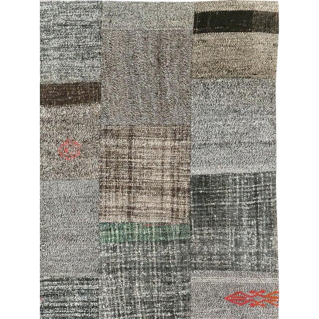 This Mid-20th century Turkish Flatweave Kilim rug, features a captivating patchwork design composed of individual...
