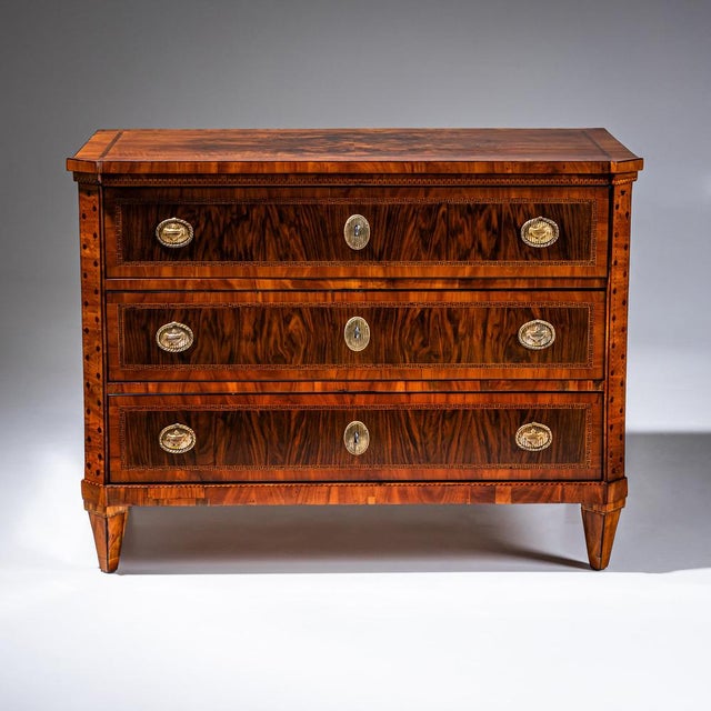 Three-drawer neoclassical chest in the so-called Zopfstil with a strict rectilinear case, chamfered corners, and...