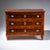 Three-drawer neoclassical chest in the so-called Zopfstil with a strict rectilinear case, chamfered corners, and...