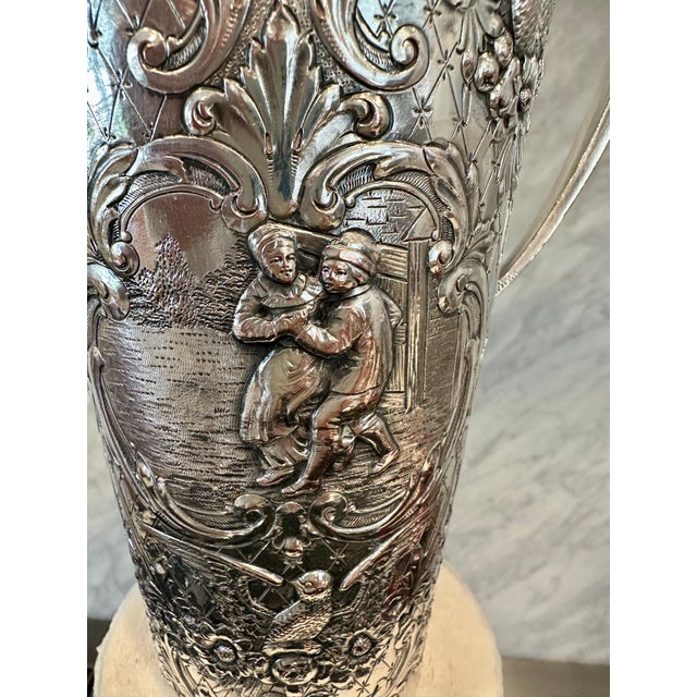 This exceptional antique, silver-plated cocktail shaker features an intricate, deeply embossed repoussé design that...