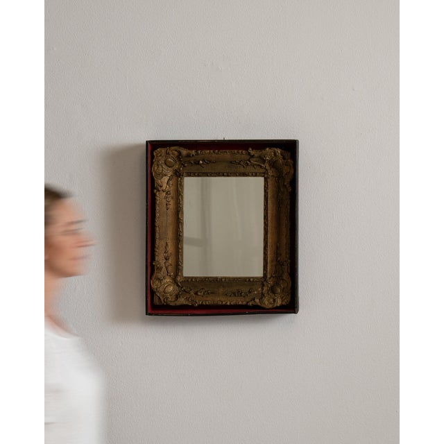 This piece presents as a mirror, distinguished by dark bronze/gold ornate carved frame with red edge. Dating to 19th...