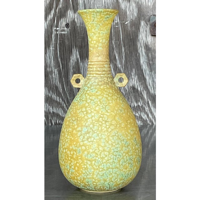 This vintage Boho studio pottery vase showcases a handcrafted design with distinctive patterns and earthy colors, adding a...