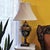 Vintage Wildwood metal table lamp made in Rocky Mount, North Carolina, featuring a hand-painted floral urn design with...