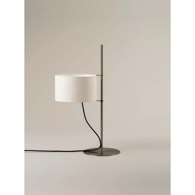 Tmd table lamp by miguel milá dimensions: d 25 x w 39 x h 65 cm materials: linen, nickel. With a structure supported by a...