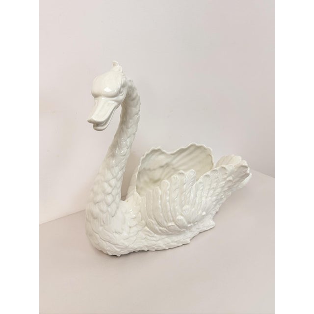 This elegant large vintage white porcelain swan planter and sculpture is a classic and eye-catching decorative piece. The...
