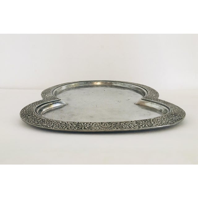 Fanciful silver plate serving tray with ornamental edge. The border has various Victorian face motifs such as greenman...