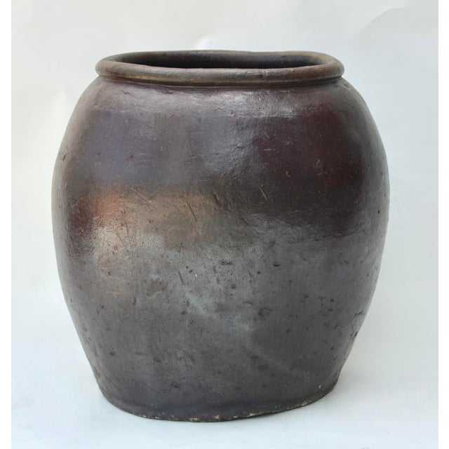 A Chinese round belly ceramic stoneware jar in a deep brown glaze. 26"T