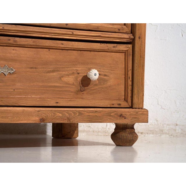 This solid pine chest of drawers is a rustic European storage piece from the early 20th century, originally used as a...