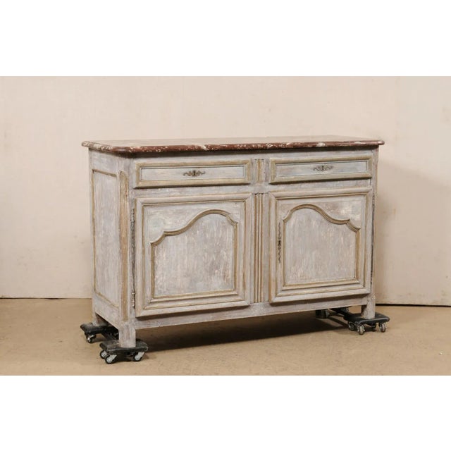 A French carved and painted wood buffet console, with original marble top, from the 19th century. This antique cabinet...