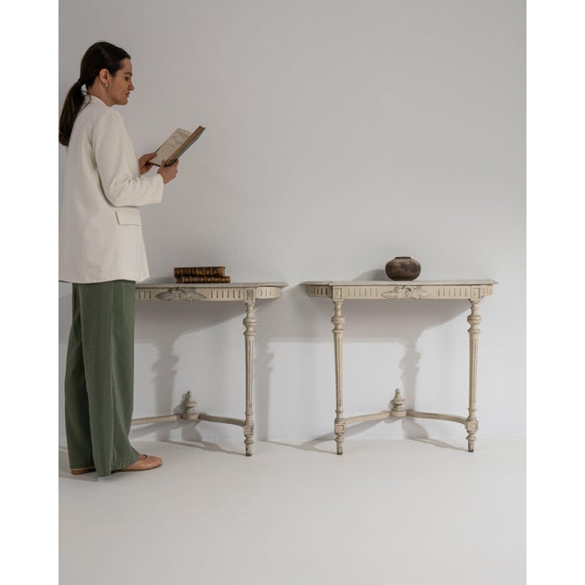 This console table carries genuine presence, its whitewashed distressed wood, iron scroll legs immediately setting the...