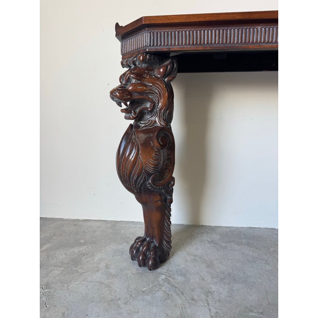 Striking vintage Hollywood Regency–style console table crafted in richly finished carved wood, featuring dramatic...
