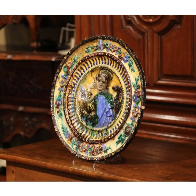 Decorate a wall with this antique and colorful barbotine platter; crafted in Italy, circa 1920, the large charger features...